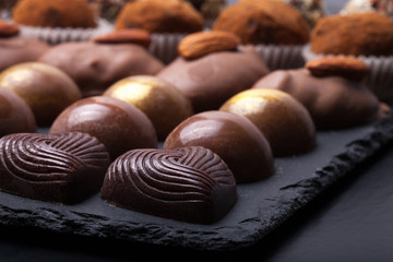 Different kinds of chocolate candies on a slate background