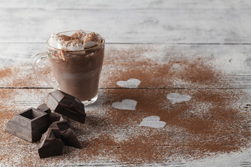 Cup of coffee with marshmallow and chocolate on wooden table