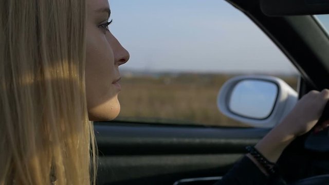 The blonde at the wheel of a car