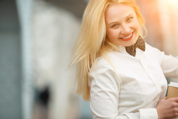 Happy smiling young blond woman in white shirt with tie