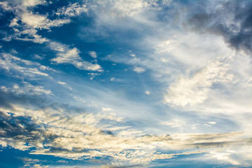 Sky blue and orange light of the sun through the clouds in the sky. The sky will change colors from blue to orange. Natural background