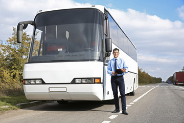Driver standing in front of bus © Africa Studio