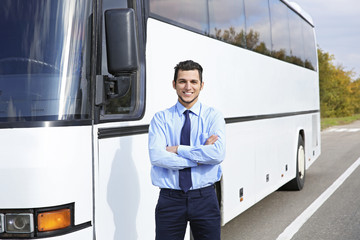 Male driver standing in front of bus