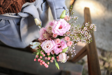 Closeup of female hands holding fresh bouquet of beautiful flowers