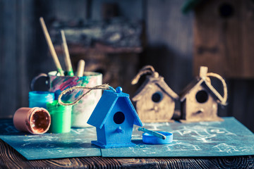 Vintage small bird feeder in wooden workshop