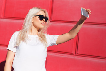 Young blond female vlogger with smartphone