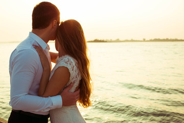 beautiful and young man and woman hug each other near the sea