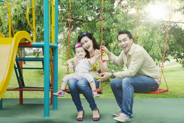 Fototapeta na wymiar Cheerful family playing together in playground
