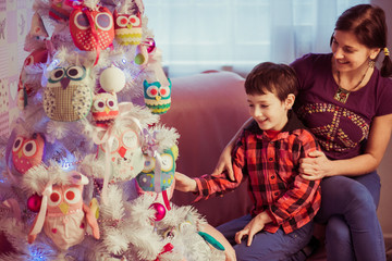 mother and son decorating Christmas tree