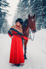 Fototapeta premium Photo Full-length of a beautiful girl and handsome stallion, horse in the winter on the nature
