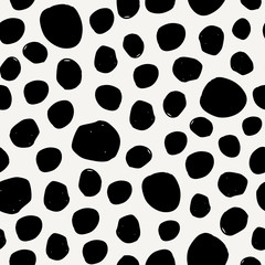 Seamless pattern with irregular dots in black on cream background.