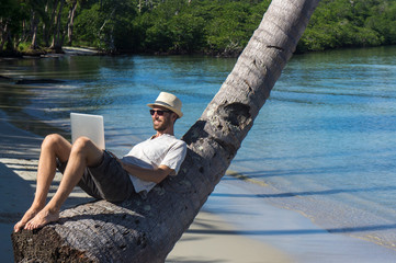 Travail sur la plage avec un ordinateur portable