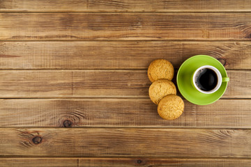 green cup with coffee and cookie