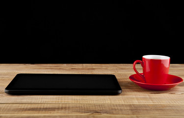 black tablet PC and coffee Cup