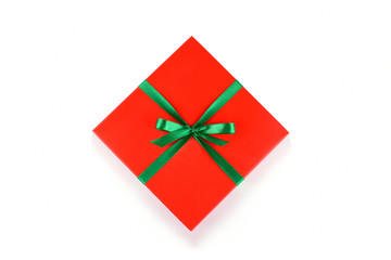 Top view of red gift box with green ribbon and bow isolated on white background