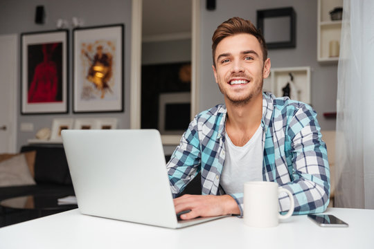 Cheerful young man using laptop computer