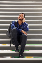 happy man sitting on steps talking on mobile phone