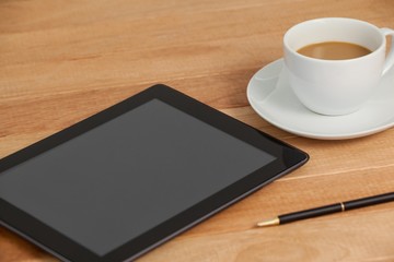 Digital tablet with pen and cup of tea