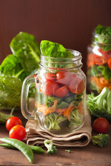 healthy vegetable salad in mason jar. tomato broccoli carrot pea