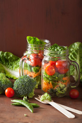healthy vegetable salad in mason jar. tomato broccoli carrot pea
