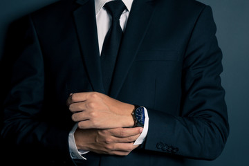 Obraz premium Businessman Fixing Cufflinks his Suit