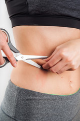 woman holding scissors to the belly on white background