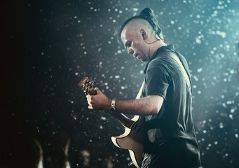 Obraz na płótnie Canvas Guitarist performing on stage.