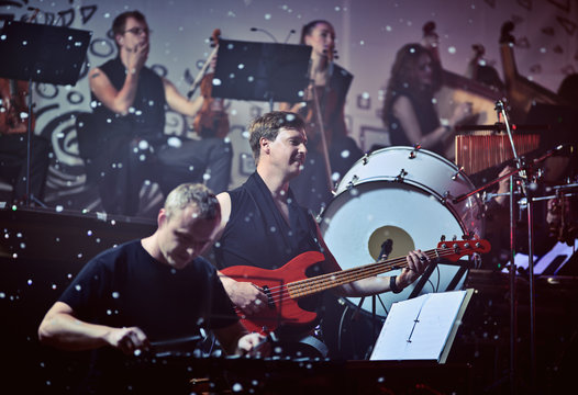 Performance of rock group and orchestra.