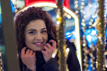 Obraz na płótnie Canvas Beautiful young woman mittens smiling outside on christmas background