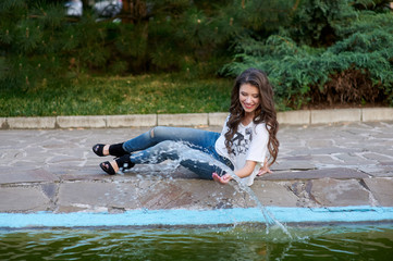 beautiful woman sitting near the fountain in the Park