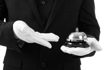 Male waiter holding bell on white background