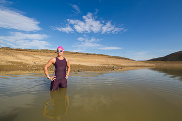 Female triathlete about to start a triathlon race in a dam