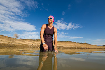 Female triathlete about to start a triathlon race in a dam