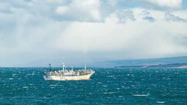 Old Fishing Boat at Sea in South America near the Coastal Port City of Punta Arenas Chile on a Windy Day with White Caps on the Pacific Ocean Water