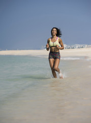 mixed race girl running on beach