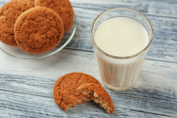 Oatmeal cookies with milk on wooden background