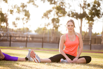 Beautiful female fitness model stretching and training on athlet