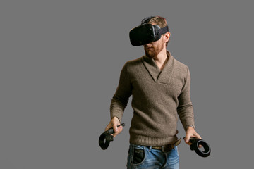 bearded man using the virtual reality headset and two controller