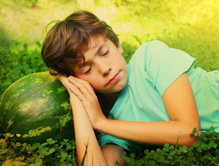 preteen boy have siesta nap with water melon