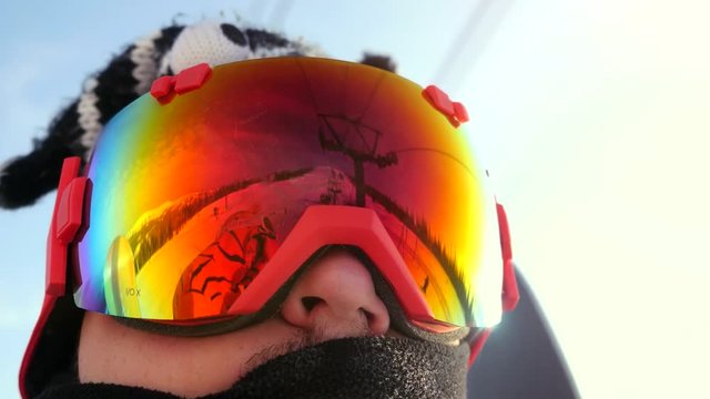 Skier in glasses skiing downhill in high mountains on ski lift during sunny day. 3840x2160