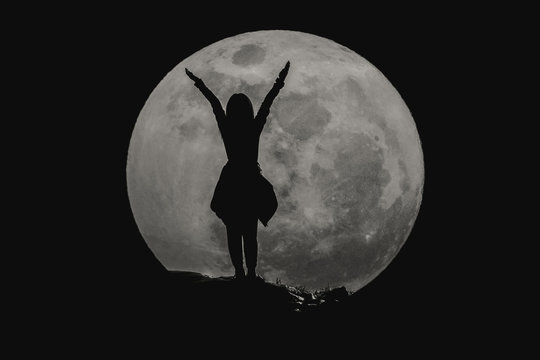 silhouette of young girl with the super full moon : success conc