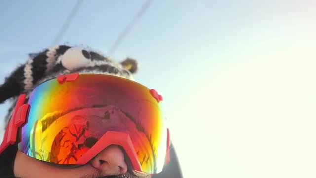 Skier in glasses skiing downhill in high mountains on ski lift during sunny day in slow motion. 1920x1080