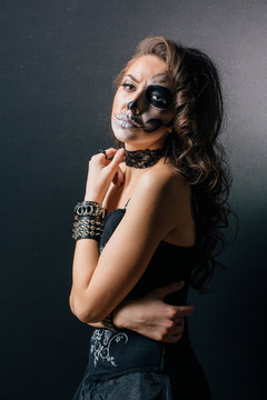 Portrait of young woman with skull make-up.