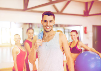 smiling man standing in front of the group in gym