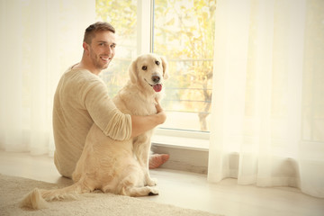Handsome man with cute dog at home