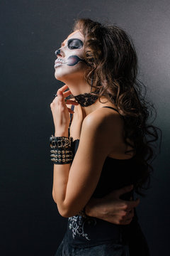 Portrait of young woman with skull make-up.