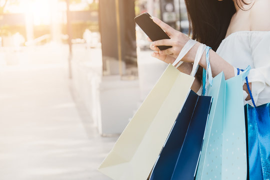 Woman hand  shopping  using smartphone with shopping bag
