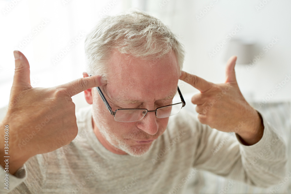 Wall mural senior man suffering from headache at home