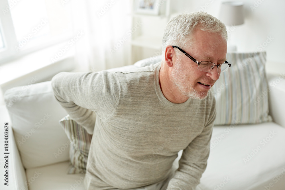 Wall mural unhappy senior man suffering from backache at home