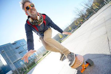 Mature man skateboarding in the street © goodluz